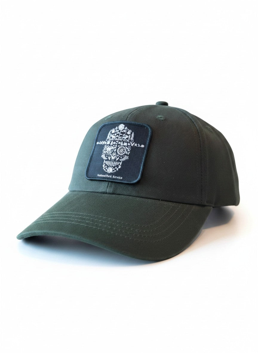 Moove Headwear dark green cotton baseball cap with a National Park Service skull patch and adjustable strap.