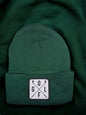 Moove Headwear dark green acrylic rib-knit golf beanie with a white square patch featuring crossed golf clubs and the letters GOLF.