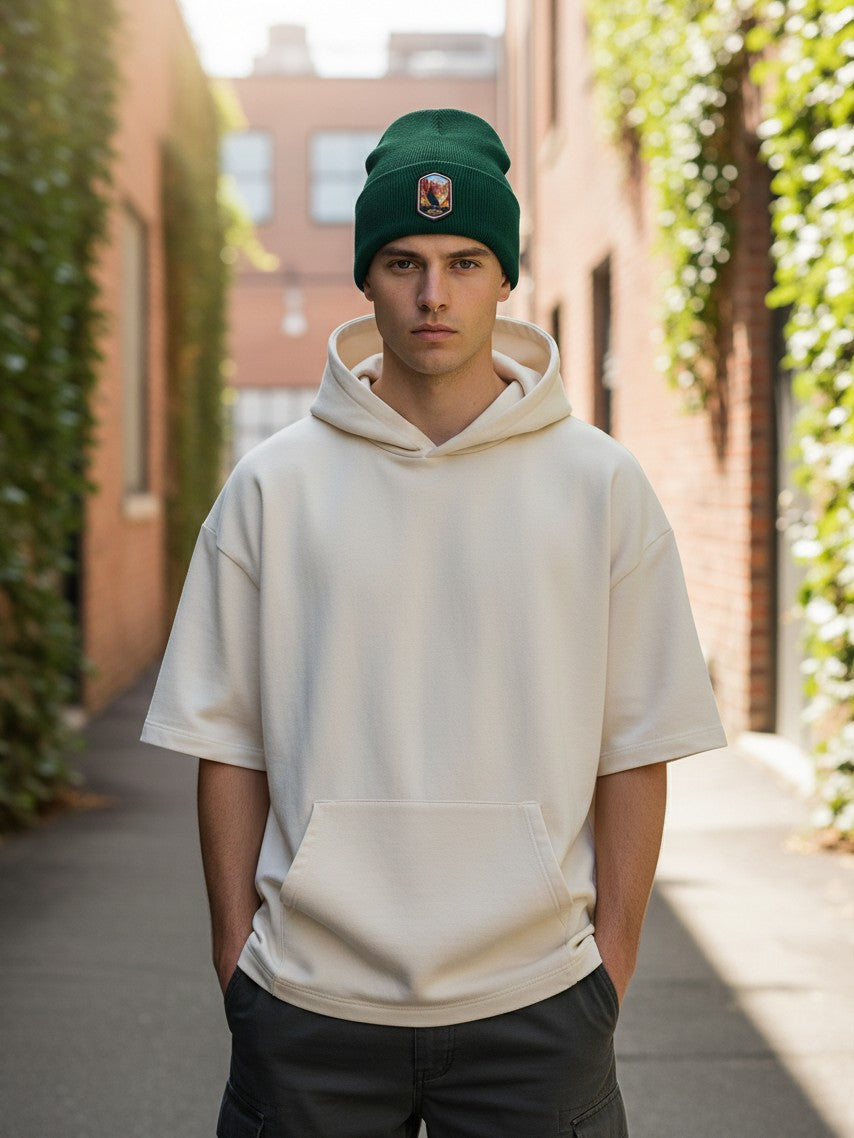 Moove Headwear green rib-knit winter beanie with a Grand Canyon woven patch worn by a man in a cream hoodie