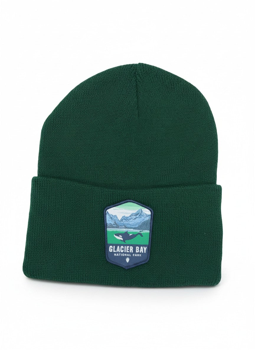 Moove Headwear dark green knit beanie with Glacier Bay National Park patch featuring a whale and mountains.