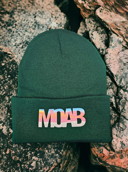Moove Headwear dark green acrylic knit beanie with a colorful "MOAB" patch, perfect for outdoor adventures.