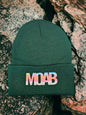 Moove Headwear dark green acrylic knit beanie with a colorful "MOAB" patch, perfect for outdoor adventures.
