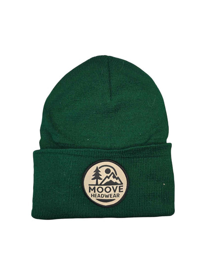 Moove Headwear forest green knit beanie with a circular logo patch featuring mountains and trees.