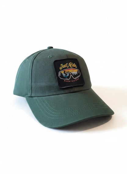 Moove Headwear dark green cotton trucker hat with "Just Ride Mountain Bike" patch and adjustable dad hat style.
