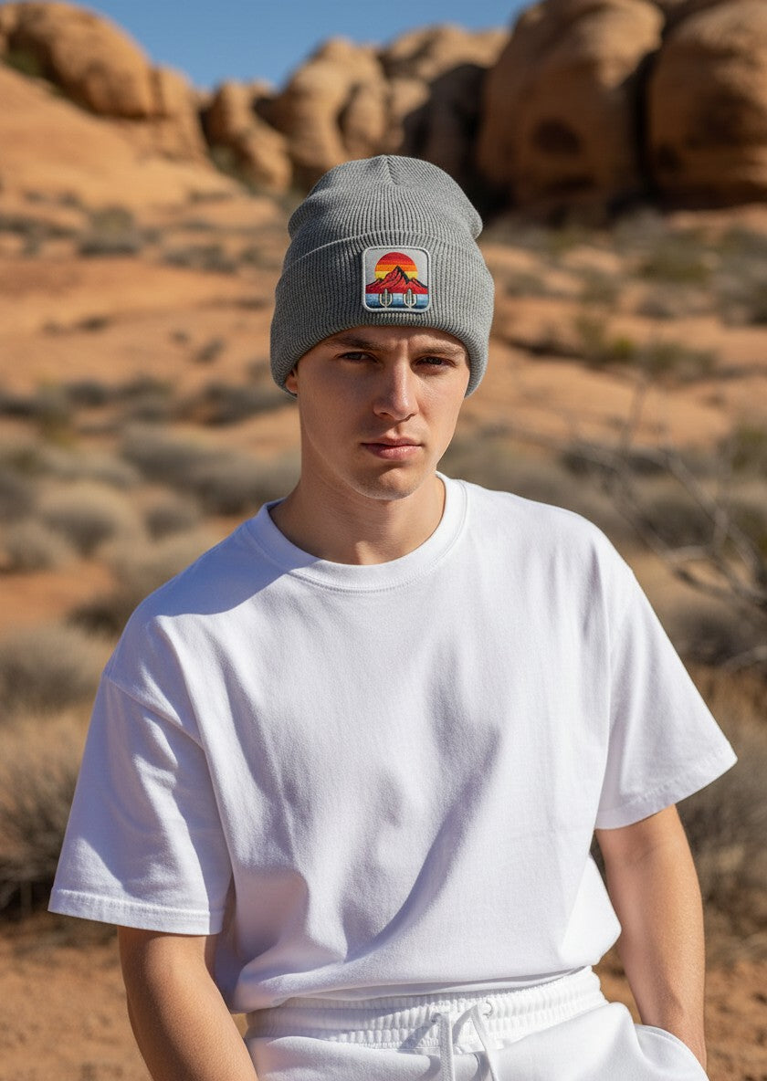 Moove Headwear grey knit beanie featuring a desert sunset and cactus patch, worn by a man in a desert landscape.