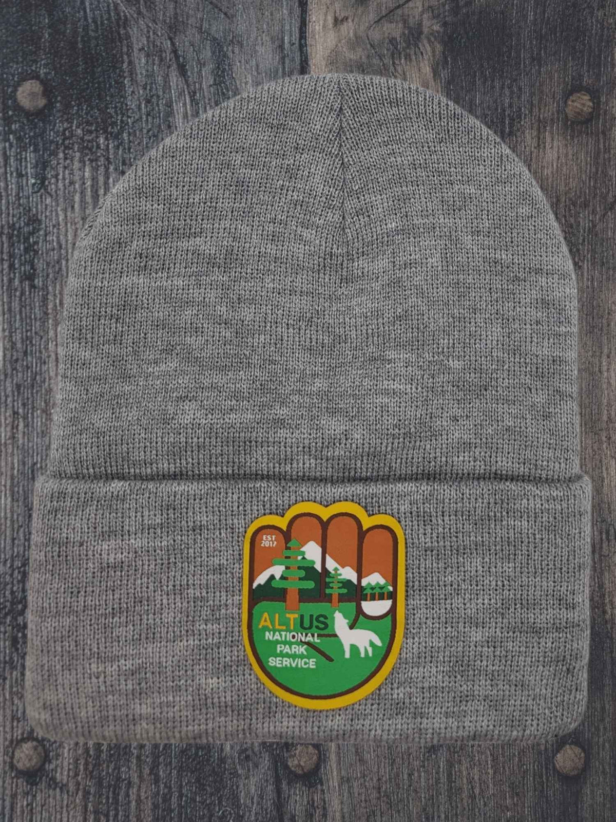 Moove Headwear grey cuffed knit beanie with AltUs National Park patch featuring a wolf and mountain design