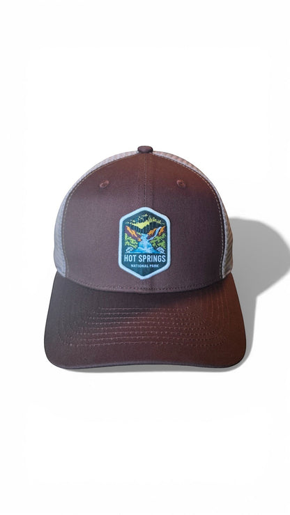 Moove Headwear brown trucker hat with mesh back and Hot Springs National Park patch. Adjustable snapback closure.