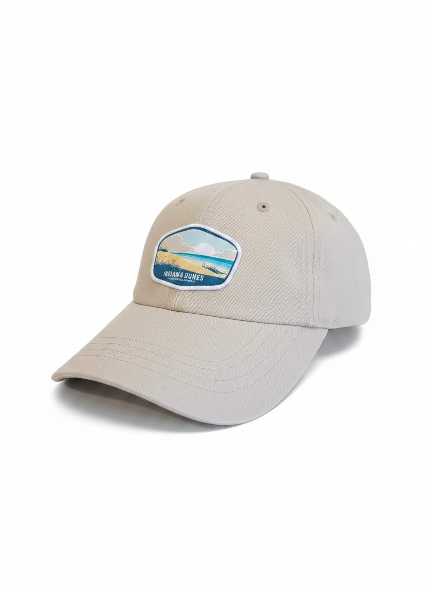 Moove Headwear tan baseball cap with embroidered Indiana Dunes National Park patch and adjustable strap.