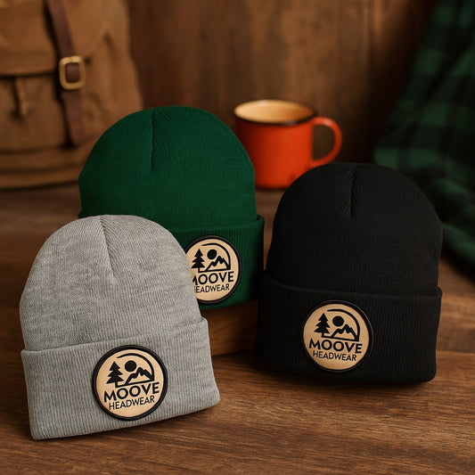 Moove Headwear heather gray, forest green, and black knit beanies with fold-over cuffs and a circular logo patch.