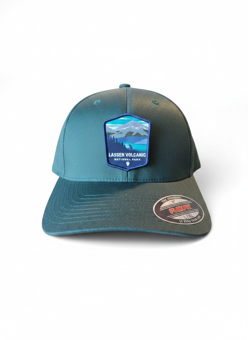Moove Headwear black Flexfit cap with embroidered Lassen Volcanic National Park patch featuring mountains and forest.