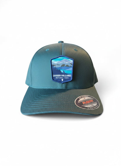 Moove Headwear black Flexfit cap with embroidered Lassen Volcanic National Park patch featuring mountains and forest.
