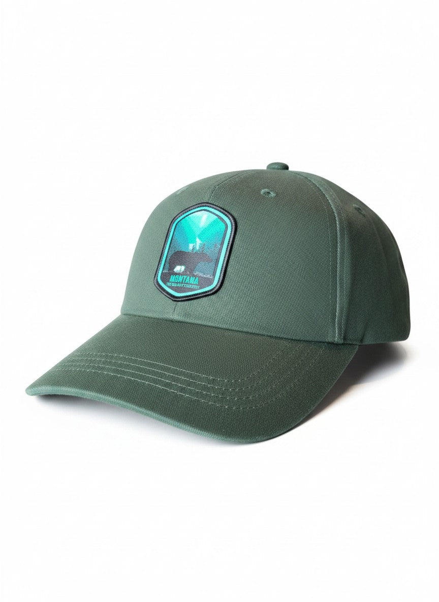 Moove Headwear dark green cotton baseball cap with Montana Big Sky Country patch featuring a bear and aurora borealis.