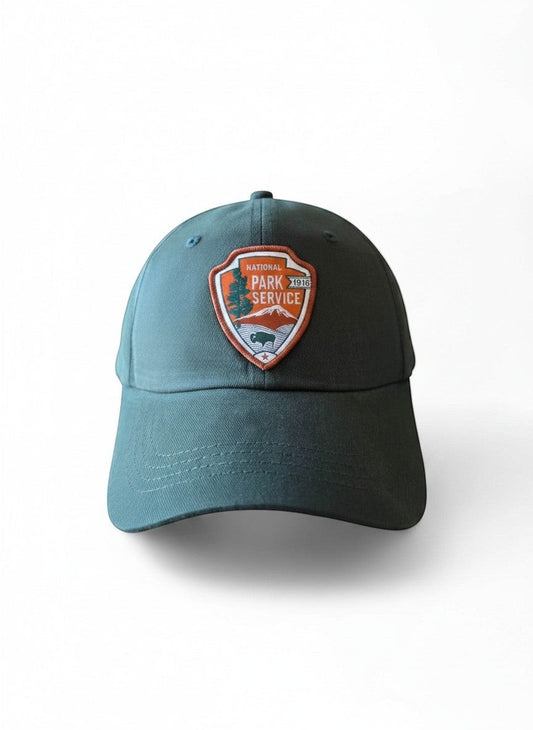 Moove Headwear green adjustable dad hat with embroidered National Park Service emblem patch.