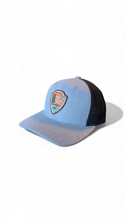 Moove Headwear light blue trucker hat with black mesh back and National Park Service badge