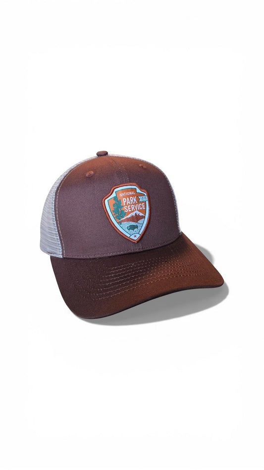 Moove Headwear brown trucker hat with National Park Service patch and white mesh back. Adjustable snapback closure.