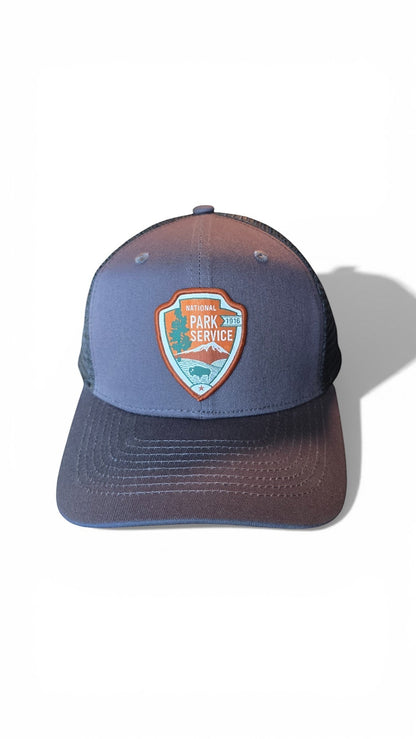 Moove Headwear National Park Service snapback hat with embroidered badge featuring mountains, trees, and a bison. Grey with black mesh back.