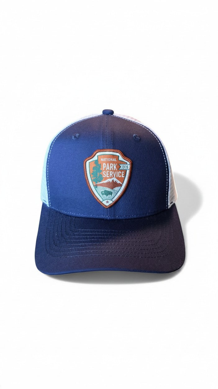 Moove Headwear navy blue and white mesh trucker hat with National Park Service patch and adjustable snapback closure.