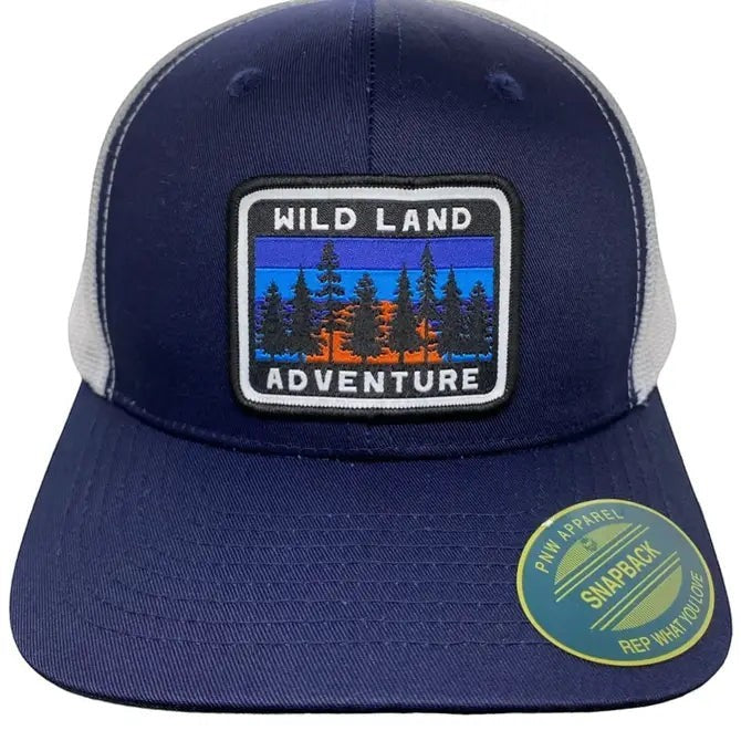 Moove Headwear navy blue trucker hat with white mesh back and "Wild Land Adventure" patch featuring pine trees and sunset.