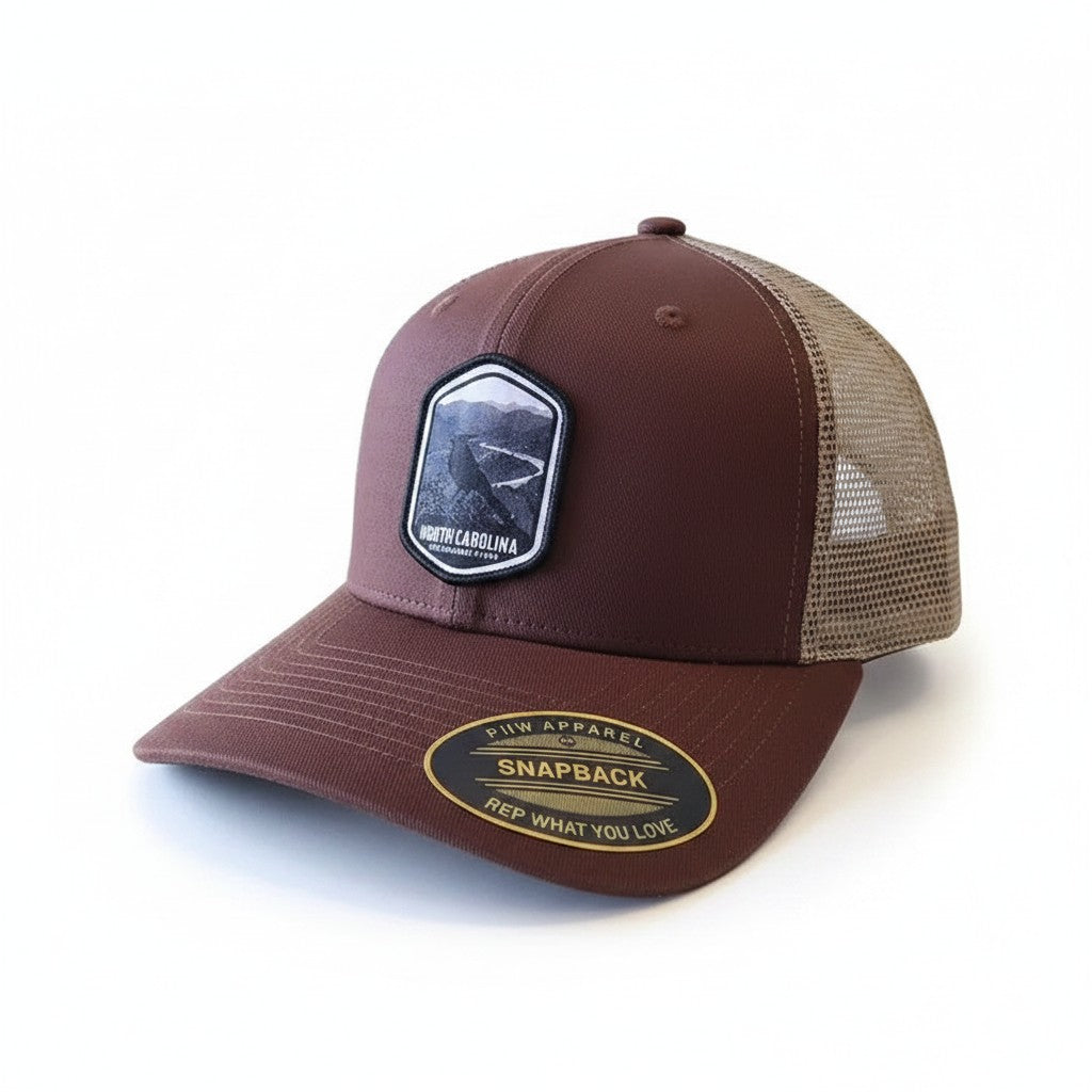 Moove Headwear North Carolina Tar Heels trucker hat with mesh back and embroidered patch. Brown fabric.
