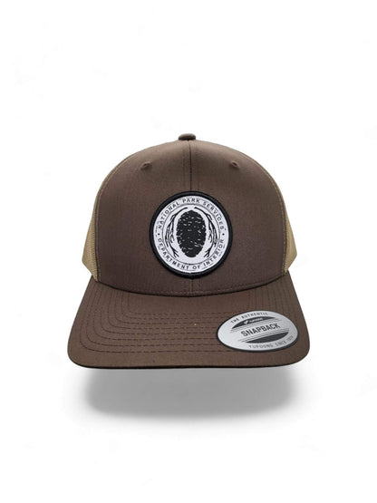 Moove Headwear brown trucker hat with National Park Service Sequoia Cone embroidered patch and tan mesh back.