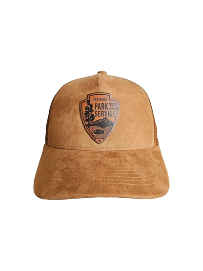 Moove Headwear brown suede trucker hat with National Park Service leather patch emblem and mesh back.