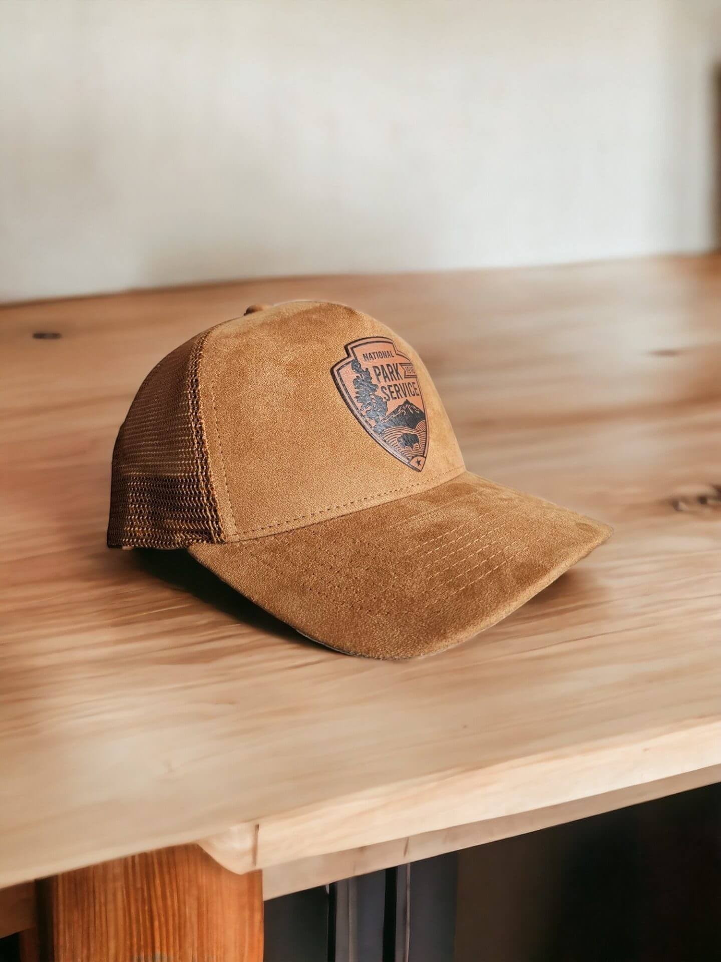 Moove Headwear tan suede trucker hat with National Park Service leather patch and mesh back panels.