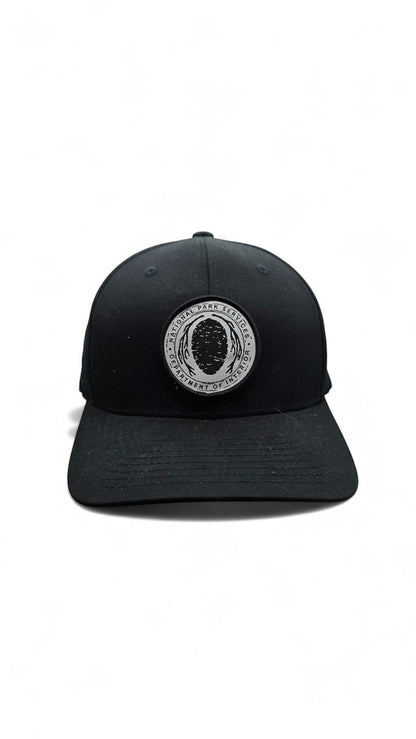 Moove Headwear black Flexfit hat with embroidered National Park Service logo patch on the front.