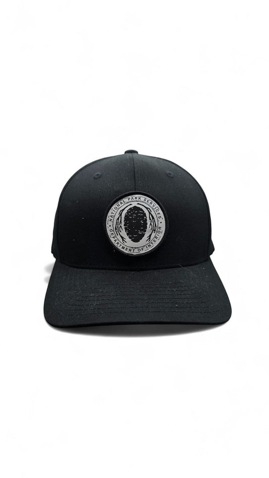 Moove Headwear black Flexfit hat with embroidered National Park Service logo patch on the front.