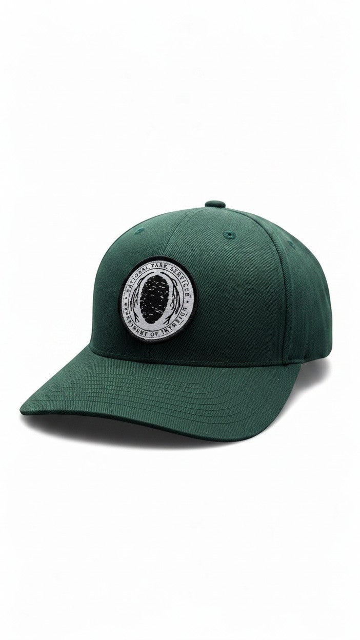 Moove Headwear dark green Flexfit hat with embroidered National Park Service logo patch on the front.