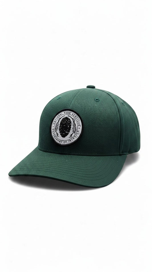 Moove Headwear dark green Flexfit hat with embroidered National Park Service logo patch on the front.