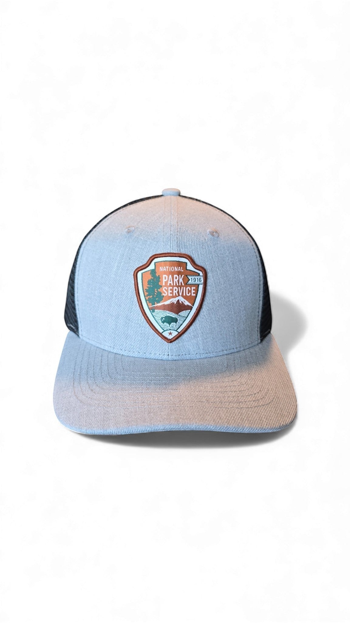 Moove Headwear National Park Service patch trucker hat, light grey with black mesh back and adjustable snapback closure.