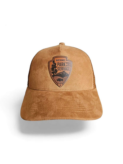 Moove Headwear tan suede trucker hat with National Park Service leather patch emblem and mesh back.