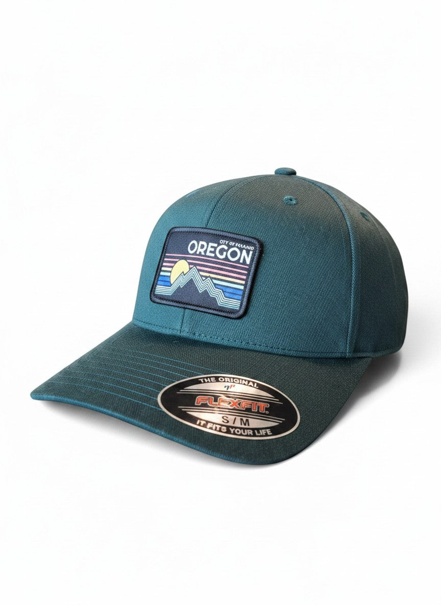 Moove Headwear dark teal baseball cap with embroidered Oregon mountain and sun patch, Flexfit technology.