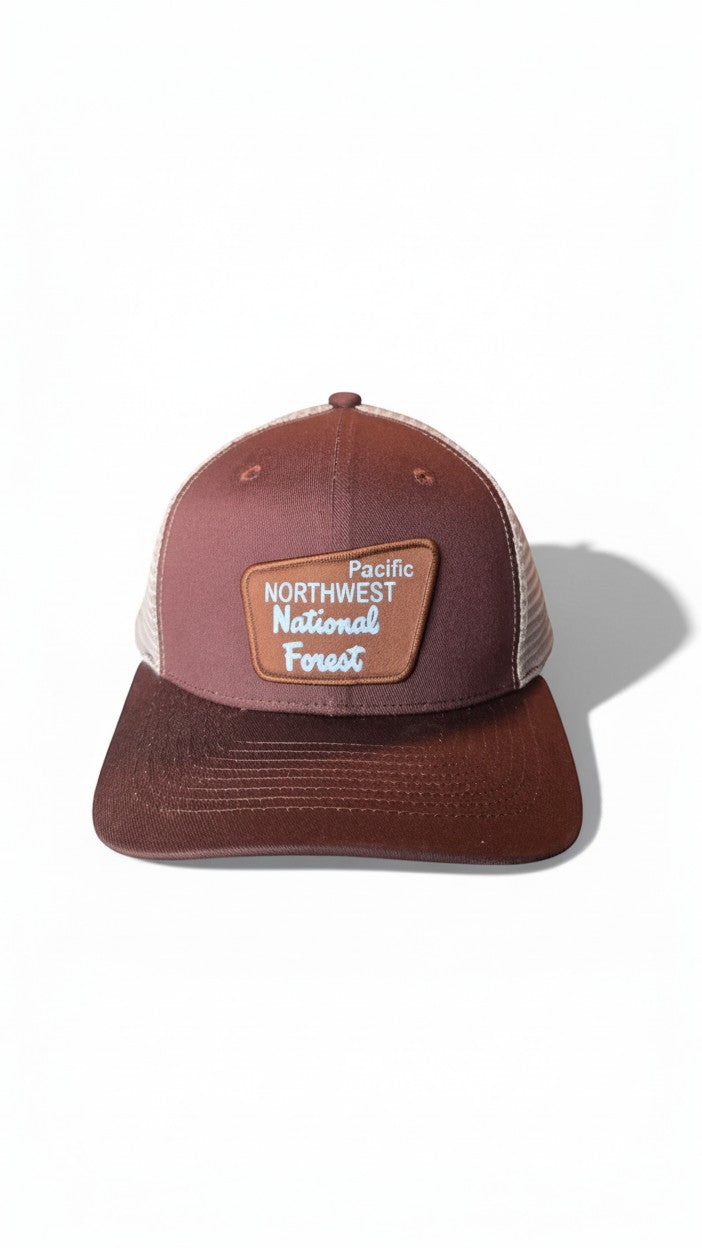 Moove Headwear Pacific Northwest trucker hat with mesh back and adjustable snapback. Brown cap with a patch.