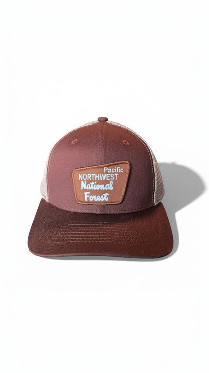 Moove Headwear Pacific Northwest trucker hat with mesh back and adjustable snapback. Brown cap with a patch.