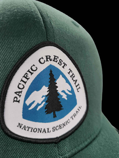Moove Headwear green Pacific Crest Trail embroidered patch cap with mountains and tree graphic.