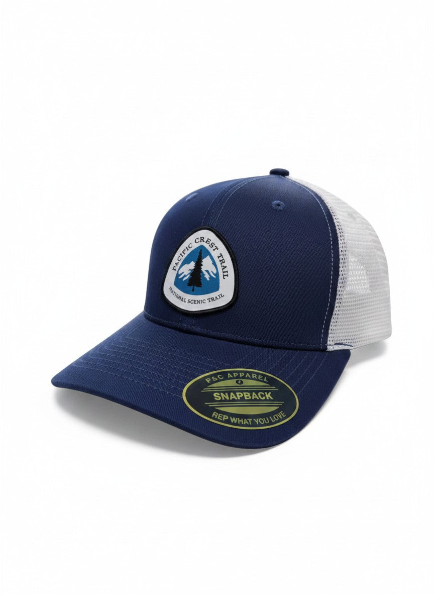 Moove Headwear navy blue trucker hat with white mesh back and Pacific Crest Trail patch. Adjustable snapback closure.