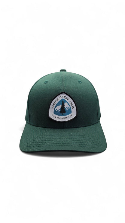 Moove Headwear dark green baseball cap with Pacific Crest Trail patch, featuring a mountain and tree graphic.