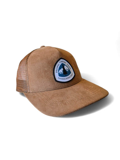 Moove Headwear tan suede trucker hat with mesh back and Pacific Crest Trail patch. Adjustable snapback for a secure fit.