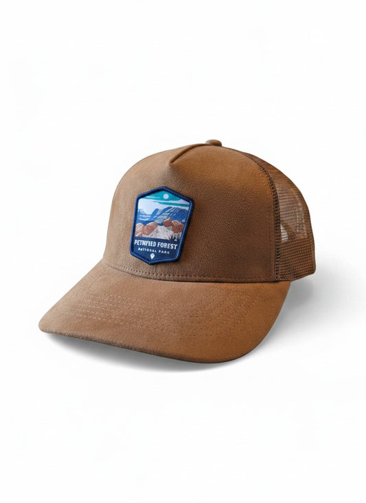 Moove Headwear tan suede trucker hat with Petrified Forest National Park embroidered patch, mesh back, and curved brim.