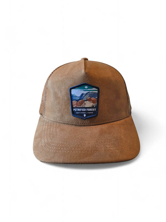Moove Headwear tan suede trucker hat with Petrified Forest National Park embroidered patch, mesh back, and curved brim.