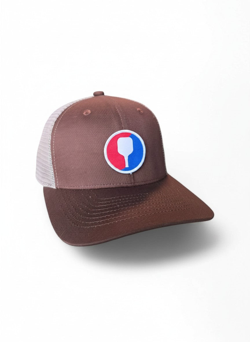 Moove Headwear brown trucker hat with mesh back and pickleball paddle patch. Adjustable snapback.