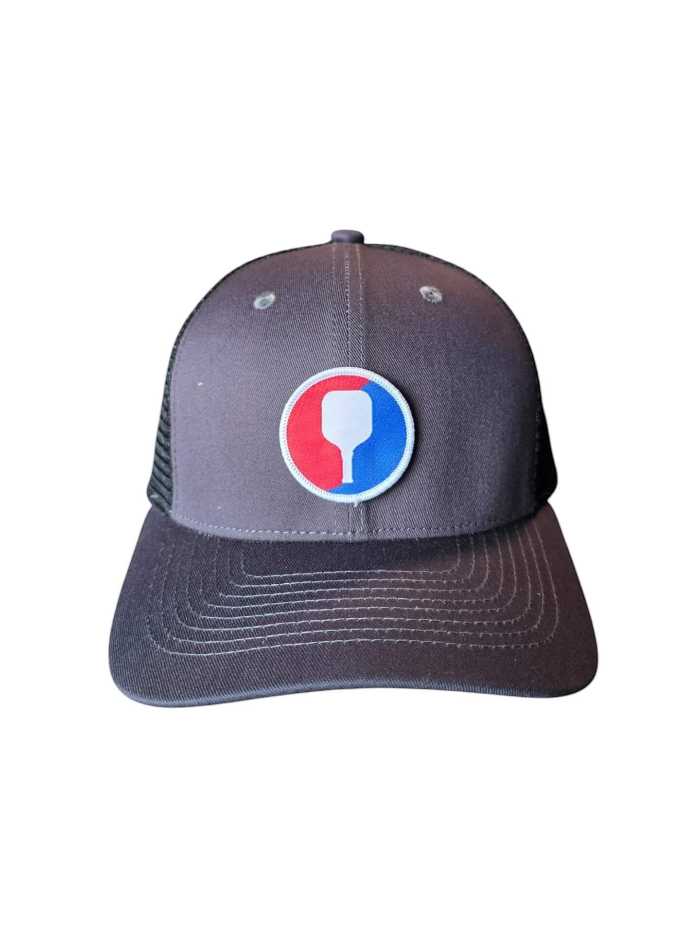 Moove Headwear grey trucker hat with pickleball paddle patch and mesh back. Adjustable snapback closure.