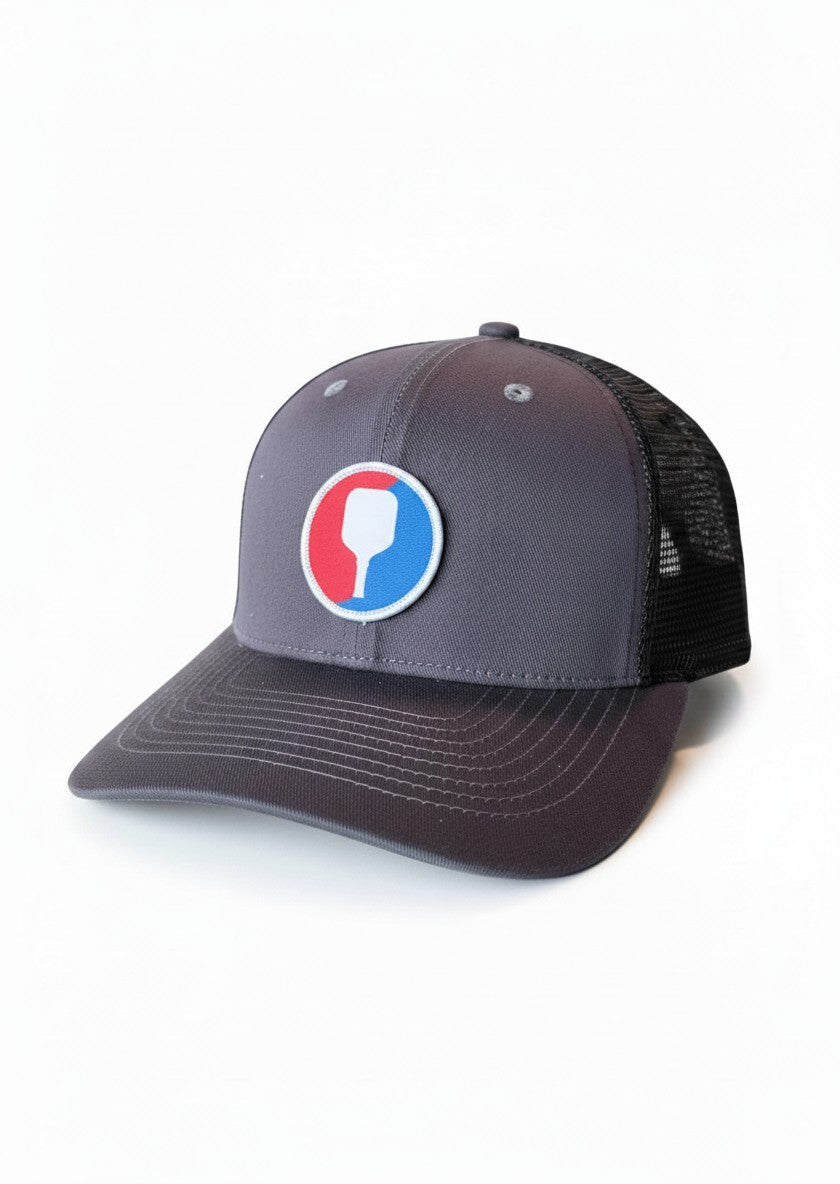 Moove Headwear grey trucker hat with pickleball paddle patch and black mesh back. Snapback closure.