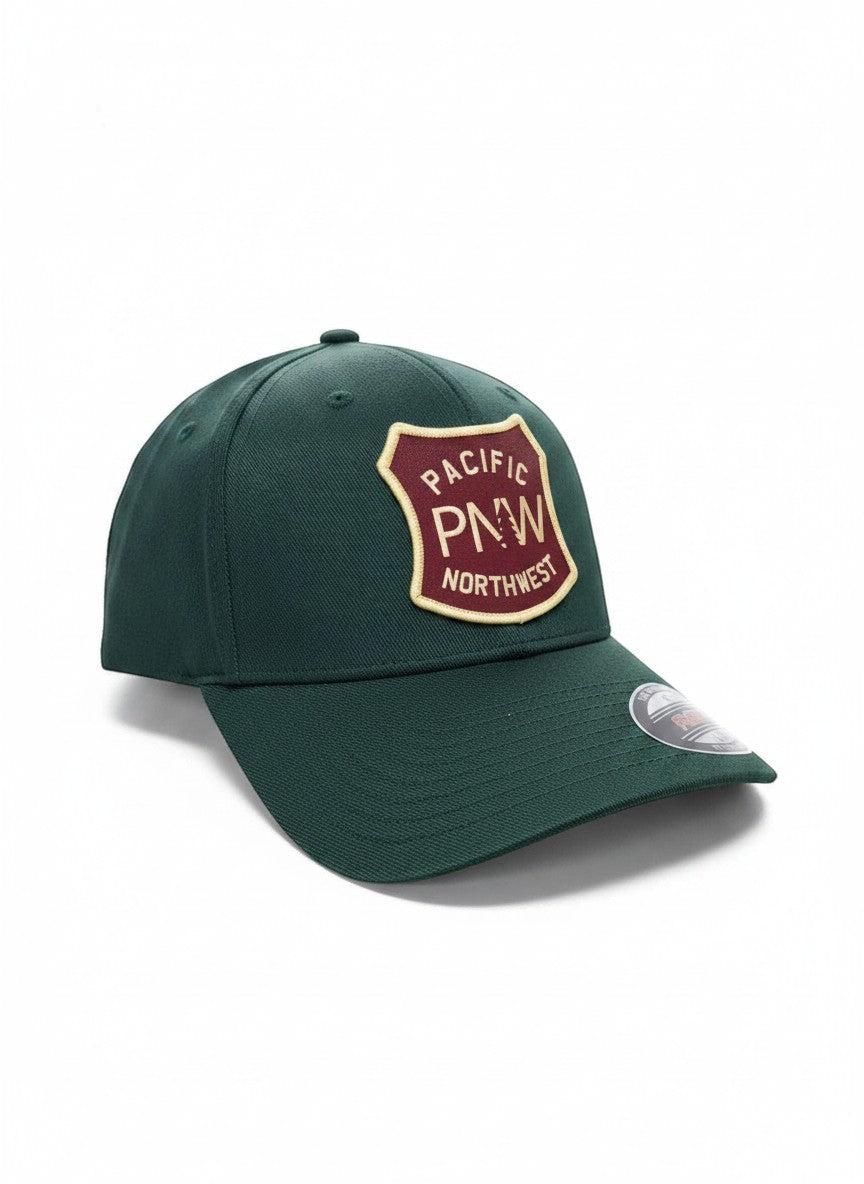 Moove Headwear dark green baseball cap with a maroon and tan PNW Pacific Northwest shield patch.