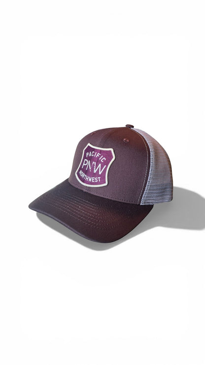 Moove Headwear brown trucker hat with mesh back and PNW tree graphic patch. Adjustable snapback.