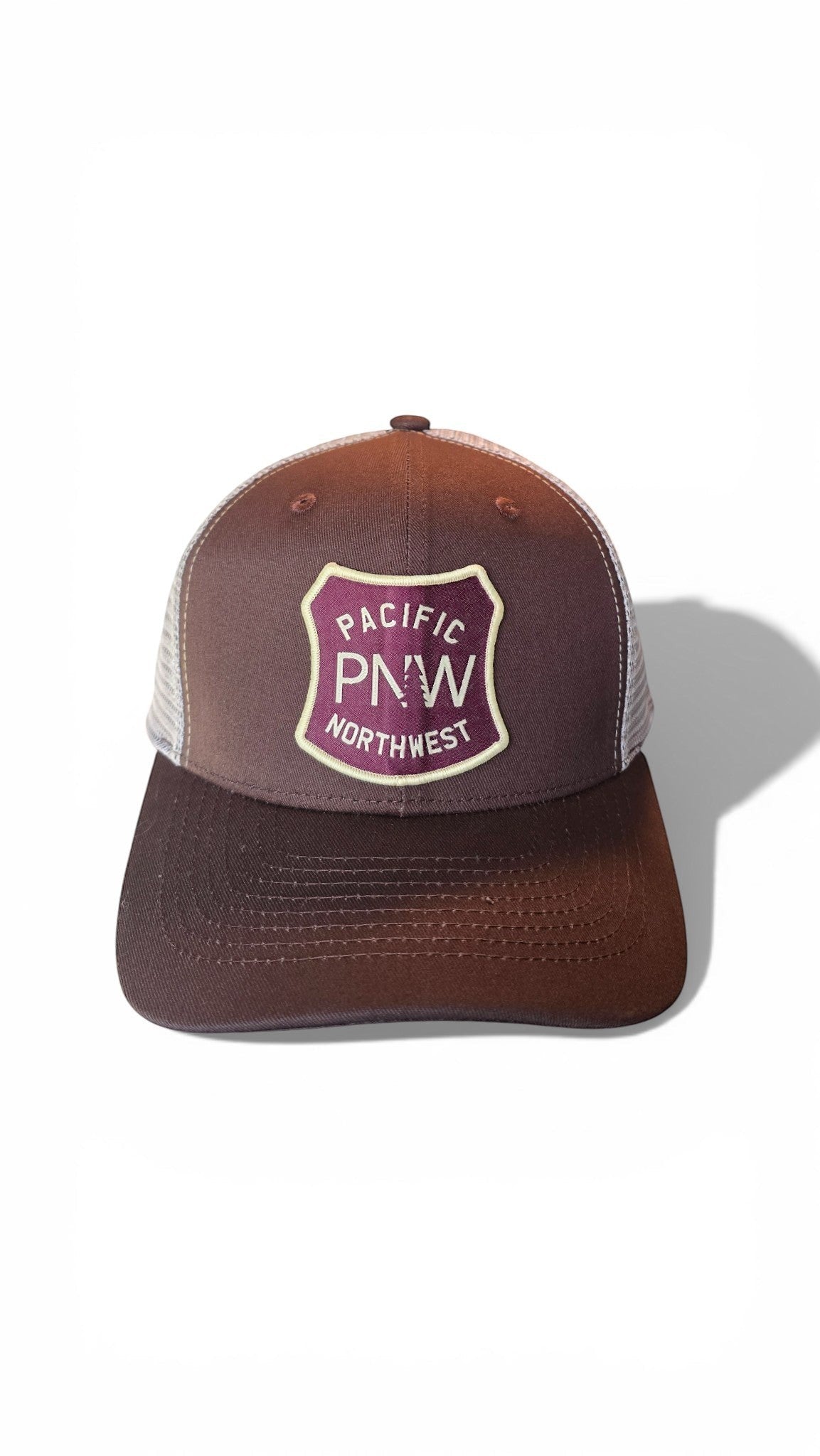 Moove Headwear brown trucker hat with mesh back and PNW tree graphic patch. Adjustable snapback for a custom fit.