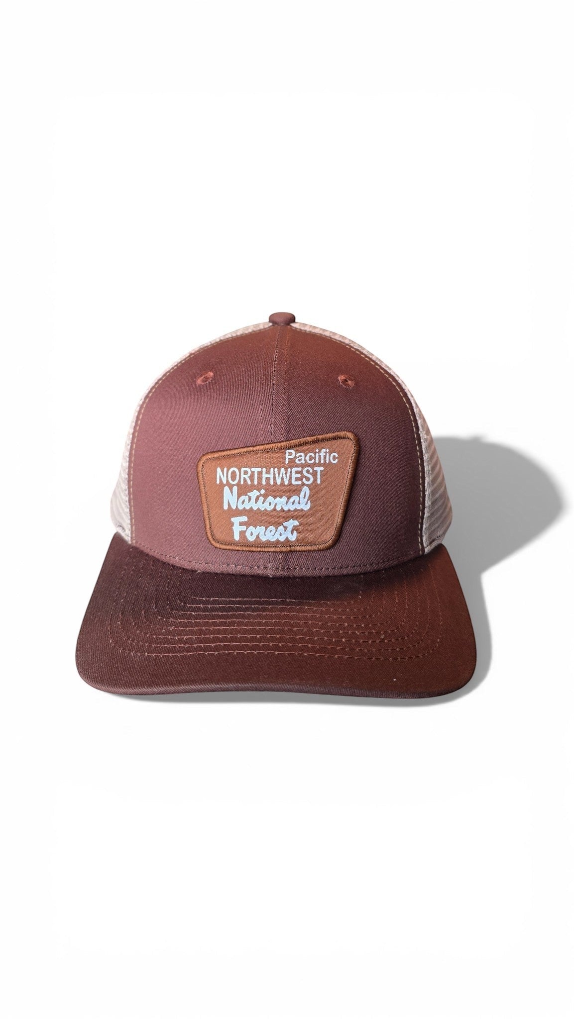 Moove Headwear Pacific Northwest trucker hat with mesh back and adjustable snapback closure. Brown cap with embroidered patch.