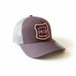 Moove Headwear Pacific Northwest trucker hat in plum with a mesh back and a shield-shaped patch with PNW graphic.