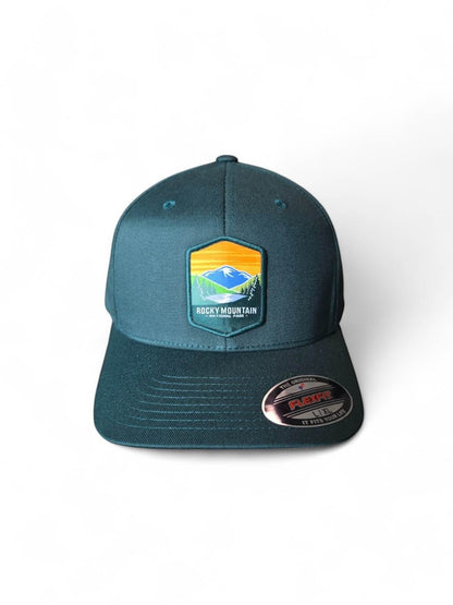 Moove Headwear Rocky Mountain National Park Flexfit baseball cap in dark teal with embroidered mountain landscape patch. Breathable fabric.